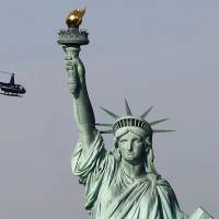 A tourist helicopter circles the Statue of Liberty Sunday in New York. The statue is closed due to the government shutdown. President Donald Trump\'s budget director is holding out hope that feuding Democrats and Republicans in Congress can reach a short-term spending agreement before the start of the workweek Monday, but he worries that the government shutdown could last for several more days if progress remains elusive. | AP