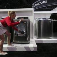 An exhibitor demonstrates an Inverter Direct Drive washing machine at the LG exhibit during the Consumer Electronics Show in Las Vegas in January 2016. | AFP-JIJI