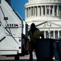 A trash collector removes garbage from Capitol Hill as the U.S. government remains shut down Saturday in Washington. | AFP-JIJI