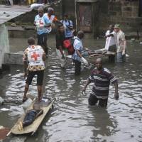 Rescue workers remove bodies of children following floods in Kinshasa, Democratic Republic of Congo, on Jan. 4. | AP