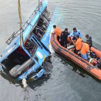 Indian police rescue people after a bus accident at the Ghogra Canal in Murshidabad district, around 187 miles from Kolkata, on Monday. At least 36 people were killed in eastern India\'s West Bengal state early Monday after the speeding passenger bus swerved off a bridge and plunged into the river, police said. | AFP-JIJI