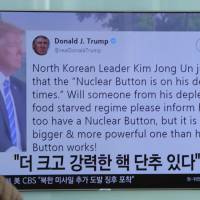 People watch a TV news program showing the Twitter post of U.S. President Donald Trump while reporting North Korea\'s nuclear issue, at Seoul Railway Station in Seoul Wednesday. Trump boasted that he has a bigger and more powerful \"nuclear button\" than North Korean leader Kim Jong Un does &#8212; but the president doesn\'t actually have a physical button. The letters on the screen read: \"More powerful nuclear button.\" | AP