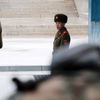 North Korean soldiers stand guard at the truce village of Panmunjom in the Demilitarized Zone (DMZ) in Paju, South Korea, on Tuesday. | BLOOMBERG