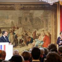 French President Emmanuel Macron watches the president of the Presidential Press Association (APP), Elizabeth Pineau, during his New Year\'s address to the press at the Elysee Palace in Paris Wednesday. | LUDOVIC MARIN / POOL / VIA AP