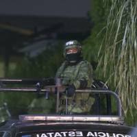 A member of the Mexican army patrols the area where seven people were killed inside a house while they were watching a soccer game in Monterrey, Mexico, Sunday. | AFP-JIJI