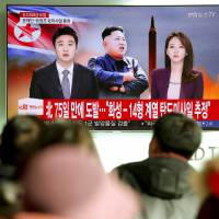 People watch a TV news report in Seoul discussing North Korea\'s test-firing of an intercontinental ballistic missile that landed close to Japan on Nov. 29. | REUTERS