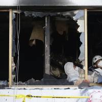 Police investigators inspect a hospital after a fire in Miryang, South Korea, on Saturday. | AP