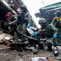 Thai military personnel inspect the site of a bomb attack at a market in the southern Thai province of Yala on Monday. | REUTERS