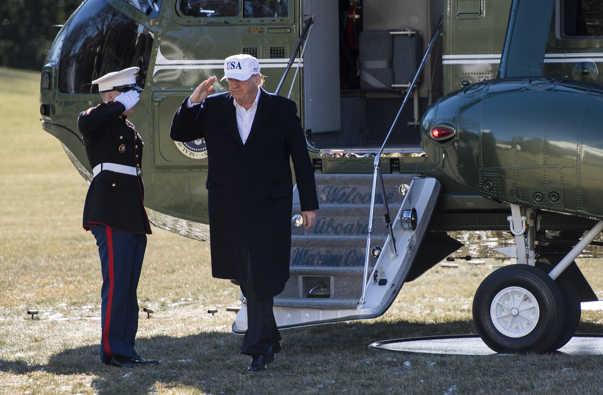 U.S. President Donald Trump salutes while disembarking from Marine One after a weekend trip with Republican leadership to Camp David, on the South Lawn of the White House in Washington Sunday. | BLOOMBERG