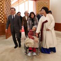 South Korean President Moon Jae-in and first lady Kim Jung-suk greet a former \'comfort woman\' at the Presidential Blue House in Seoul on Jan. 4. | REUTERS