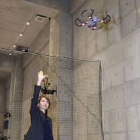 Mei Watanabe, head of Drone Museum Horie in the city of Osaka, controls a drone with hand gestures on Dec. 15. | KYODO