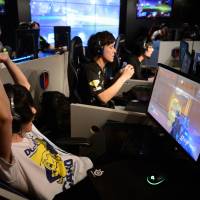 Gamers participate in the AOC Open esports event in Tokyo last July. | BLOOMBERG