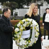 Beatrice Fihn, executive director of the International Campaign to Abolish Nuclear Weapons, and Akira Kawasaki, a member of the group\'s international steering committee, place a wreath at the Cenotaph for A-bomb Victims in Hiroshima on Monday. | KYODO