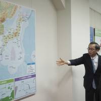 Tetsuma Esaki (right), minister in charge of territorial issues, is guided through an exhibit at Tokyo\'s National Museum of Territory and Sovereignty following an opening ceremony at the facility on Thursday. | AP