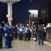 Police and railway staff gather Saturday on a train platform at Okayama Station in the city after a boy was found walking on the tracks of the Sanyo Shinkansen Line. | KYODO