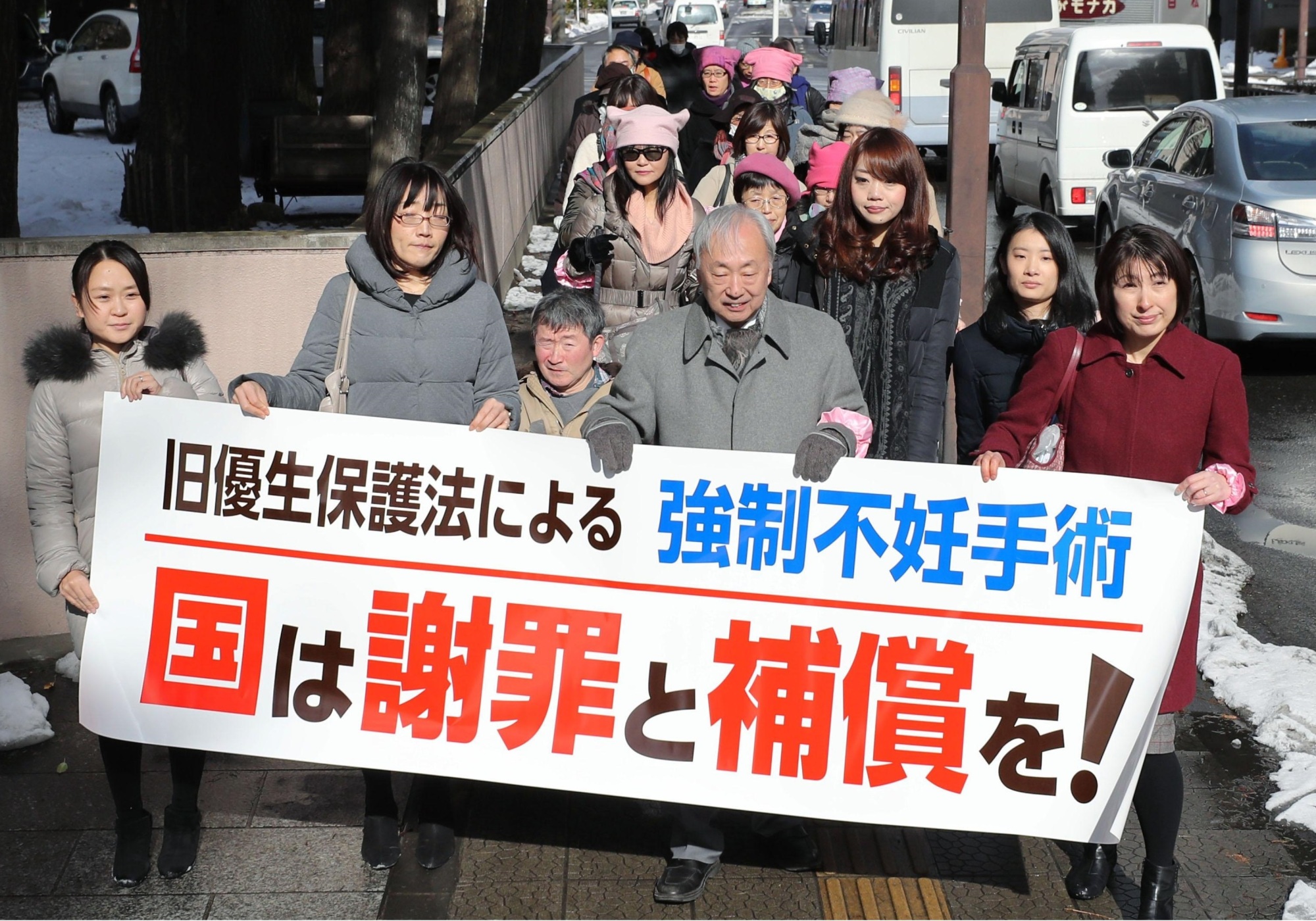 A group of lawyers holding a banner walk to the Sendai District Court on Tuesday, where they were representing a woman suing the government over her sterilization conducted under the now-defunct Eugenic Protection Law. | KYODO