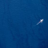 A boat moves through an oil slick on the surface of the East China Sea left by oil leaking from the sunken Iranian tanker Sanchi. | XINHUA / VIA AP