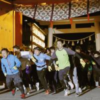 Runners in the annual \"Lucky Man Run\" set off from the gate of Nishinomiya Shrine in Nishinomiya, Hyogo Prefecture, on Wednesday. The shrine has been holding the race for centuries and anoints the top three finishers as the year\'s lucky men or women. | KYODO