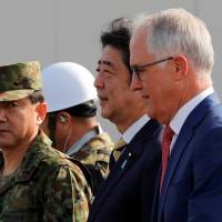Prime Minister Shinzo Abe and Australian Prime Minister Malcolm Turnbull arrive at Narashino exercise field in Chiba Prefecture on Thursday.  | REUTERS