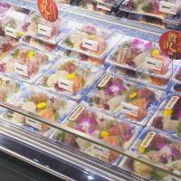 Sashimi is displayed in recycled food trays. | FP CORP.