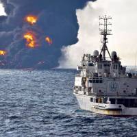 A rescue ship sails near the burning Iranian oil tanker Sanchi in the East China Sea off the eastern coast of China on Sunday. | AP