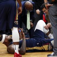 New Orleans center DeMarcus Cousins lies on the court while being tended to after injuring his left Achilles tendon, according to the team, during the second half of Friday\'s game against Houston. | AP
