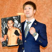 Kosei Tanaka holds up a photo of Filipino Ronnie Baldonado, his opponent for a March 31 bout in Nagoya. Tanaka will make his flyweight debut in the fight. | KYODO