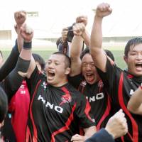 The Hino Red Dolphins celebrate their 20-17 victory over the NTT Docomo Red Hurricanes in the Top League relegation-promotion playoffs on Saturday in Osaka. | KYODO