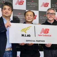 New Balance Japan Inc. President Tomoo Tomita (left), footwear designer Hitoshi Mimura (center) and vice president of New Balance\'s Global Running Tom Carleo pose for a photo in Tokyo on Wednesday. | KAZ NAGATSUKA