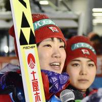 Yuki Ito speaks into a microphone as Sara Takanashi listens after a World Cup ski jumping event in Yamagata on Sunday. | KYODO