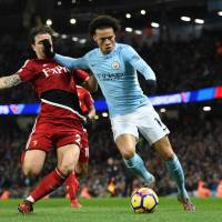 Manchester City\'s Leroy Sane holds off Watford\'s Daryl Janmaat during their Premier League game on Tuesday.  City won 3-1. | AFP-JIJI