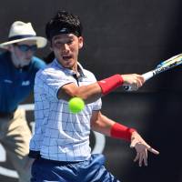 Yuichi Sugita hits a return against Ivo Karlovic during the second round of the Australian Open on Wednesday in Melbourne, Australia. | AFP-JIJI