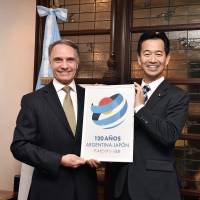 Argentinian Ambassador Alan Beraud (left) poses for a photo alongside Mitsunari Okamoto, parliamentary vice-minister for foreign affairs, during an event to celebrate the 120th anniversary of diplomatic ties between Argentina and Japan at the ambassador\'s official residence on Dec. 19. | YOSHIAKI MIURA