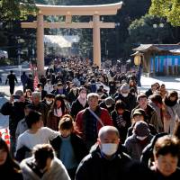 Throngs of people make their way to offer prayers on the first day of the new year at Meiji Shrine in Tokyo on Monday. An estimated 3 million people are expected to visit the shrine in the first three days of the year. | REUTERS