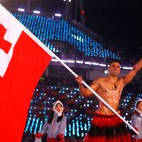 Pita Taufatofua of Tonga carries the national flag. | REUTERS