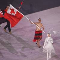 Pita Taufatofua of Tonga carries the national flag in the opening ceremony. | REUTERS