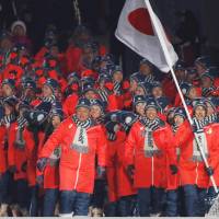 Noriaki Kasai of Japan carries the national flag during the opening ceremony. | REUTERS