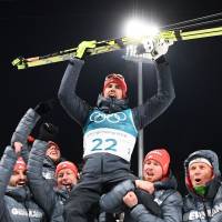 Germany\'s Arnd Peiffer is carried by team members as they celebrate his gold win during the victory ceremony following the men\'s 10km sprint biathlon event. | AFP-JIJI