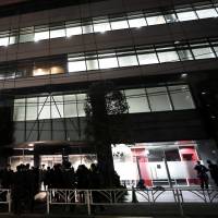 People stand outside Coincheck Inc.\'s headquarters in Tokyo on Feb. 13. | BLOOMBERG