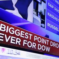 A TV screen on the floor of the New York Stock Exchange shows the day\'s headlines at the close of trading Monday. | AP