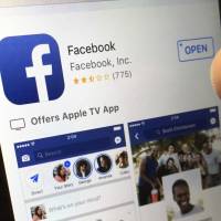 A user gets ready to launch Facebook on an iPhone, in North Andover, Massachusetts, last June. The Seattle Ethics and Elections Commission said in a statement Monday that Facebook is violating city and state laws that require disclosure of who pays for political advertising. | AP