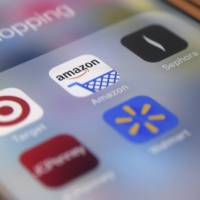 Applications on an iPhone show retailers such as Target and Amazon are embracing mobile applications to help consumers save money and time with features like digital wallets and augmented reality. | AP