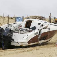 The speedboat belonging to sportswear maker Quiksilver CEO Pierre Agnes iies beached in Hossegor, southwestern France, Tuesday. | AP
