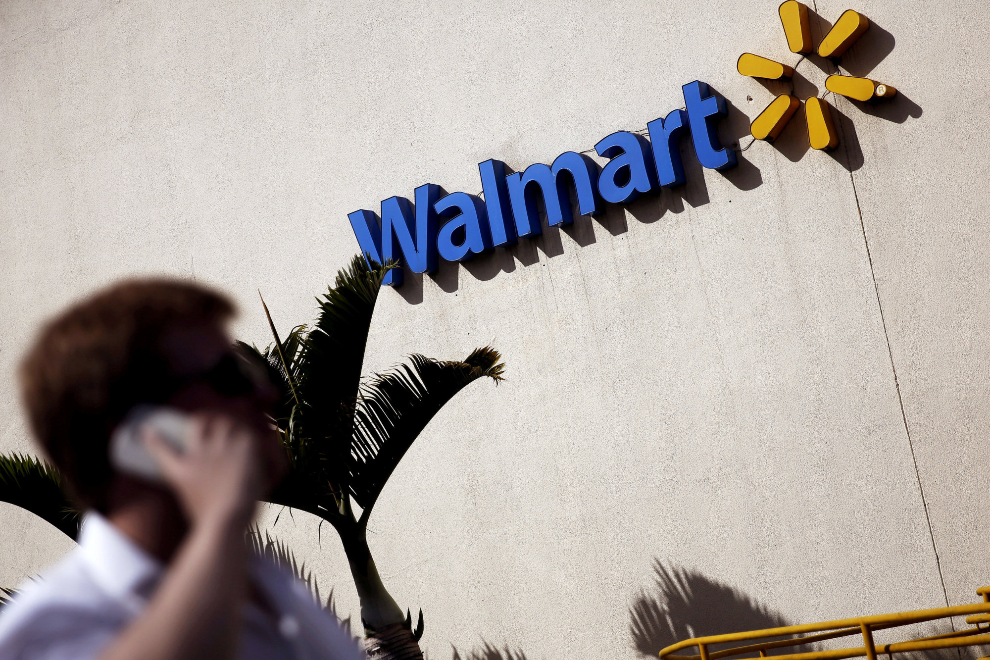 A man talks on his mobile phone in front of a Walmart store in Sao Paulo in 2016. | REUTERS