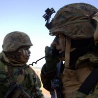 U.S. Marines listen to radio commands during the annual joint exercises with the South Korea military west of Seoul in March 2003. | BLOOMBERG