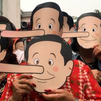 Pro-democracy activists wearing masks mock Thai Prime Minister Prayuth Chan-ocha as Pinocchio during a protest against the junta at a university in Bangkok on Saturday. | REUTERS