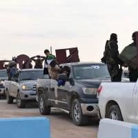 A picture taken Tuesday shows a convoy of pro-Syrian government fighters arriving in Syria\'s northern region of Afrin. Kurdish forces said in a statement that pro-regime fighters deployed to Afrin will take up positions and \"participate in defending the territorial unity of Syria and its borders,\" countering Turkey\'s offensive on the area. | AFP-JIJI