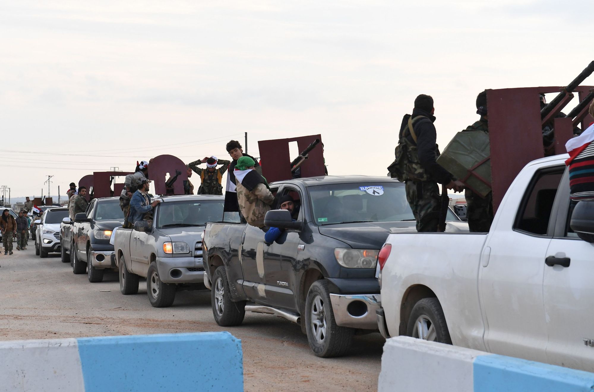 A picture taken Tuesday shows a convoy of pro-Syrian government fighters arriving in Syria's northern region of Afrin. Kurdish forces said in a statement that pro-regime fighters deployed to Afrin will take up positions and 'participate in defending the territorial unity of Syria and its borders,' countering Turkey's offensive on the area. | AFP-JIJI