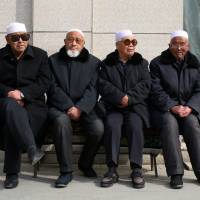 Men wait for afternoon prayers to begin at a mosque in Linxia, in China\'s Gansu province, home to a large population of ethnic minority Hui Muslims, on Feb. 1. | REUTERS