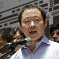 Rep. Kenji Fujimori speaks to the media outside the Congress building in Lima on Wednesday. | AFP-JIJI